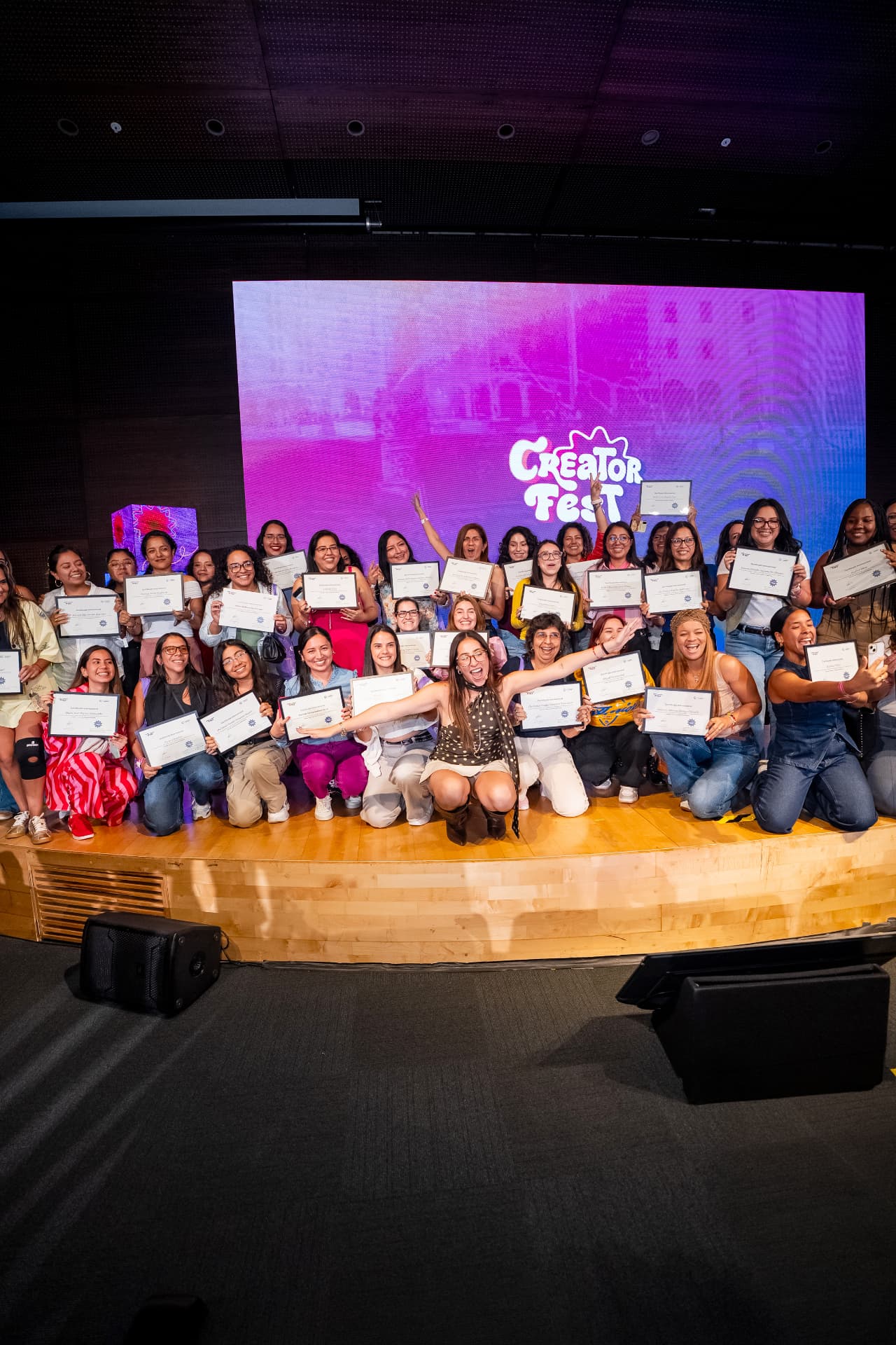 Participantes del Creator Fest 2026 celebrando en el escenario con sus certificados